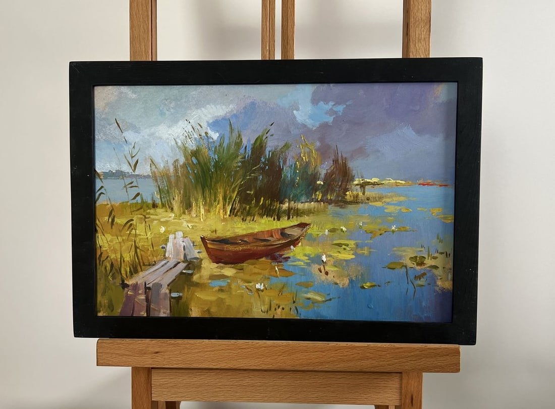 Oil painting A boat among the reeds Yuriy Suprunchuk: NoAAA4265 The painting "A Boat Among the Reeds" captures a tranquil riverside moment, where nature embraces a small wooden boat resting in the shallow waters of a peaceful lake. The scene is bathed in