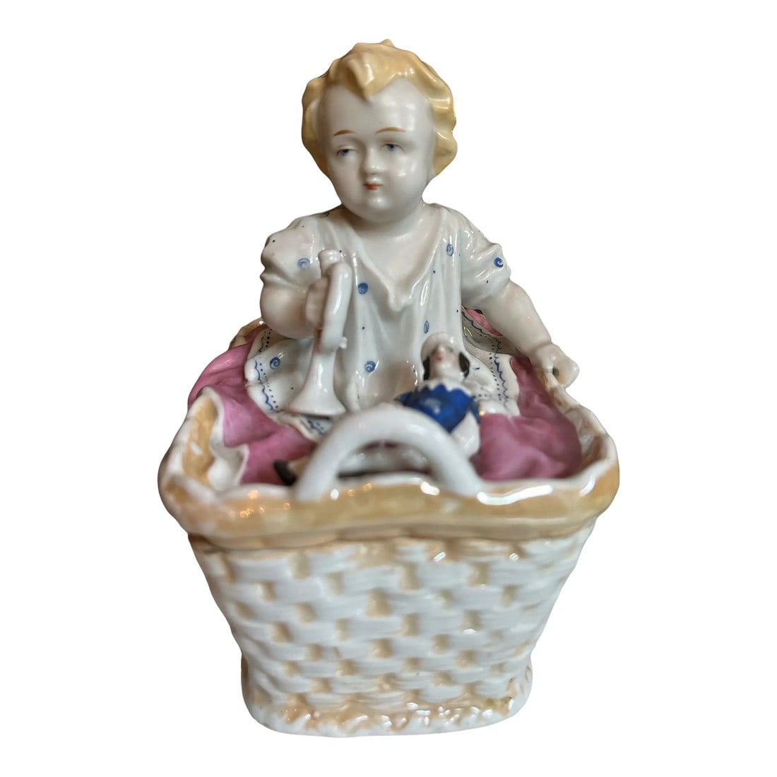 Antique 1880s Porcelain Fairing Trinket Memento Box Baby in Basket: 1880s fine porcelain trinket box in the form of a blond baby in a basket with doll and trumpet horn. Hand painted and finely molded - porcelain box weave is transparent. Impeccable condition. A sweet