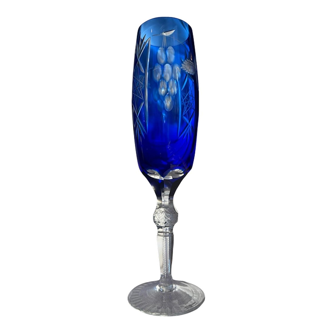 1980s Bohemian Cobalt Blue Cut to Clear Crystal Champagne Flute: Cobalt-blue crystal fluted champagne Bohemian cut to clear patterned with stars, fans, grapes and floral. Crisscross fine cuts on knob stem. A beautiful single just for you, or add to a collection.