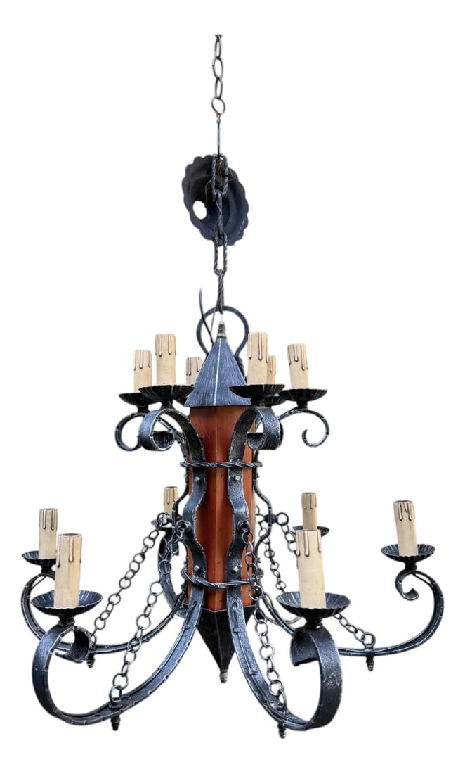 1970s Made in Italy Mediterranean Revival Wrought Iron Style 12 Light Candle Chandelier: Offering a vintage castle-era chandelier inspired by historical periods known for their elaborate ironwork and grand fixtures. It retains the original metal tag marked 'Made in Italy'- a Mediterranean