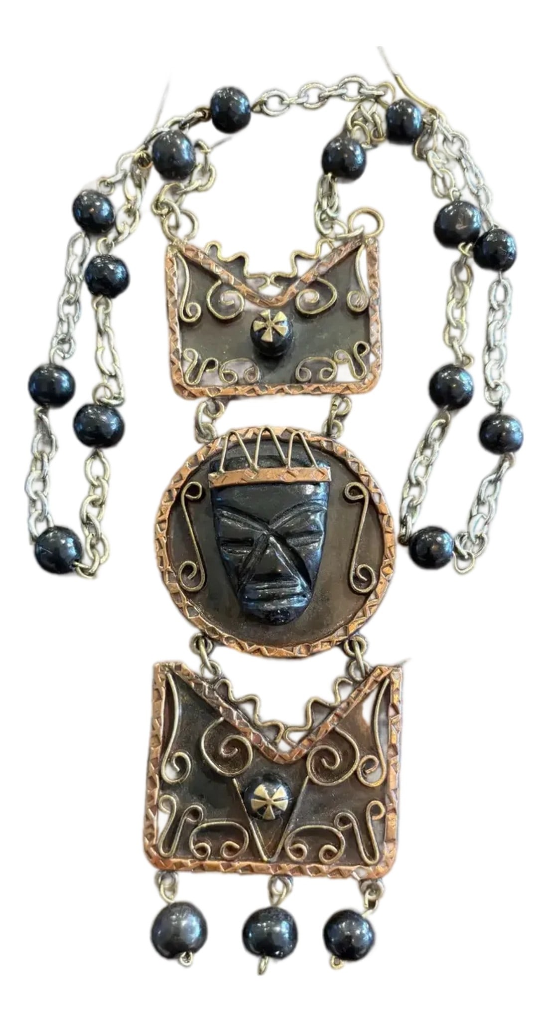 Vintage Aztec Carved Black Onyx, Brass, and Copper Necklace: This is a very unique Mid-Century Aztec black onyx, bronze, and copper necklace depicting a human face carved in the jade. Make a statement with this wearable piece of art. Made in Mexico. Length: