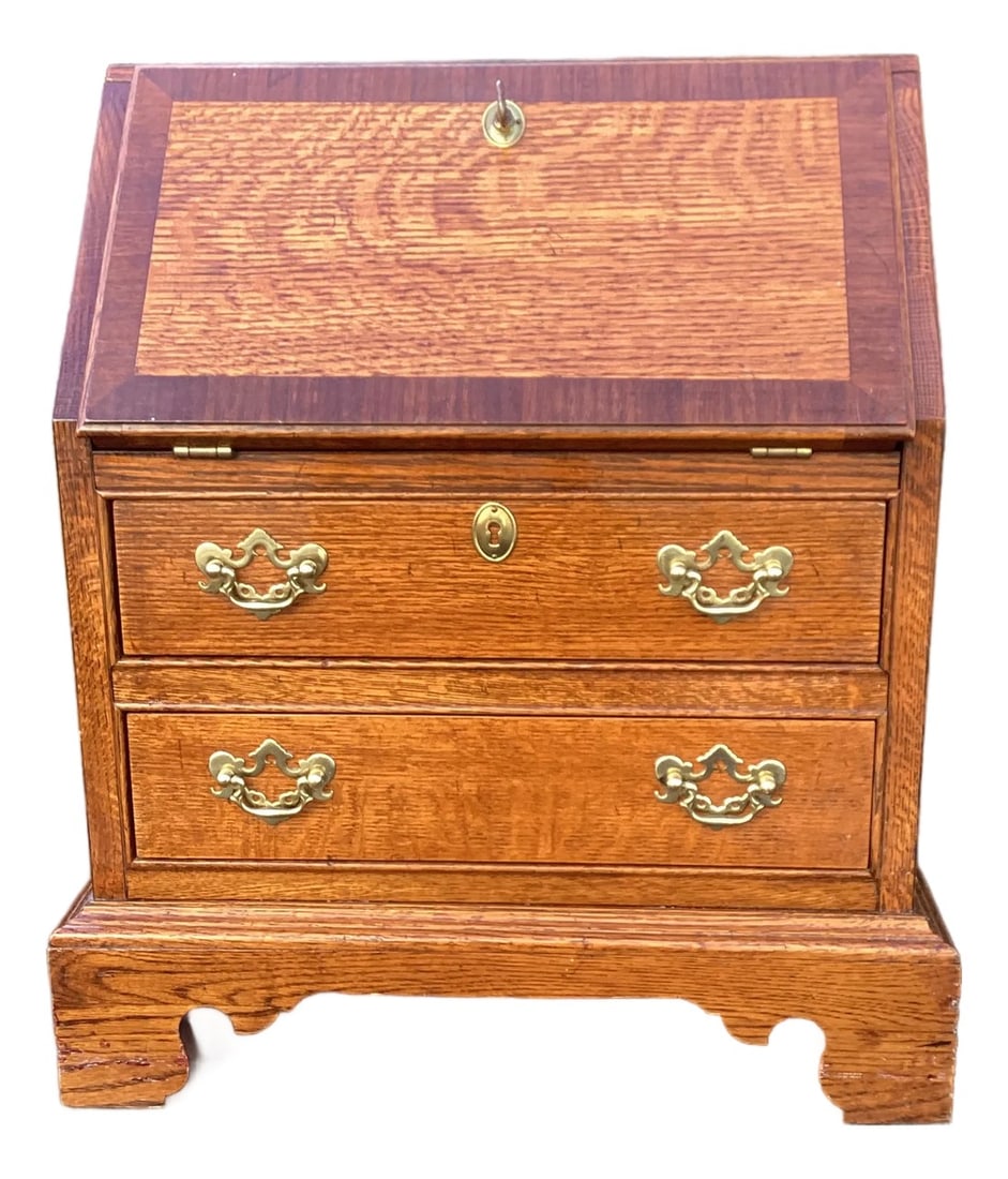 Vintage Child Sized Oak Drop Front Secretary Desk: Vintage child's secretary desk in warm oak tones with classic brass hardware. Features a drop-front writing surface and two lower drawers for storage. Its compact scale makes it ideal for a child's