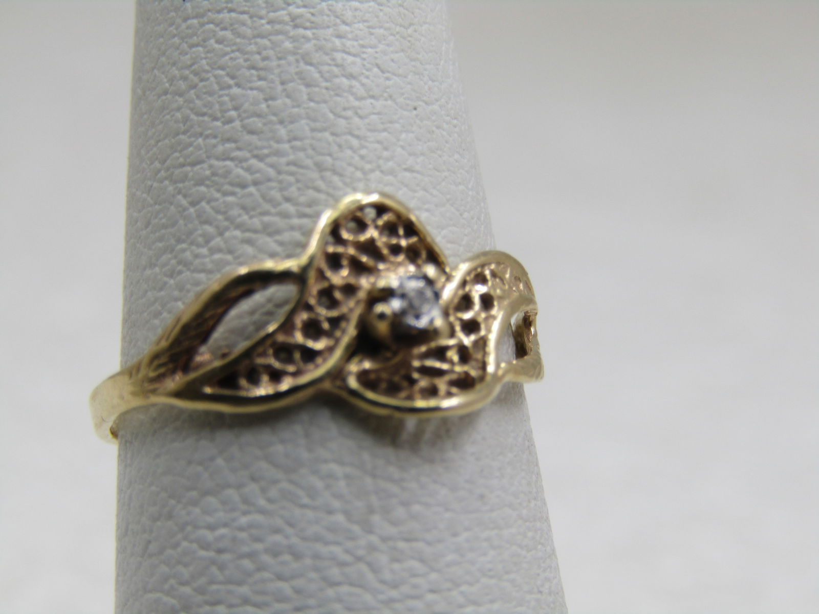 Vintage 10kt Filigree Diamond Ring, Sz. 5: Title:Vintage 10kt Filigree Diamond Ring, Sz. 5Description:Vintage 10kt Filigree Diamond Ring, Sz. 5. It is set in white gold on top center and is appx. 1.1mm wide. The ring has a crisscross filigree
