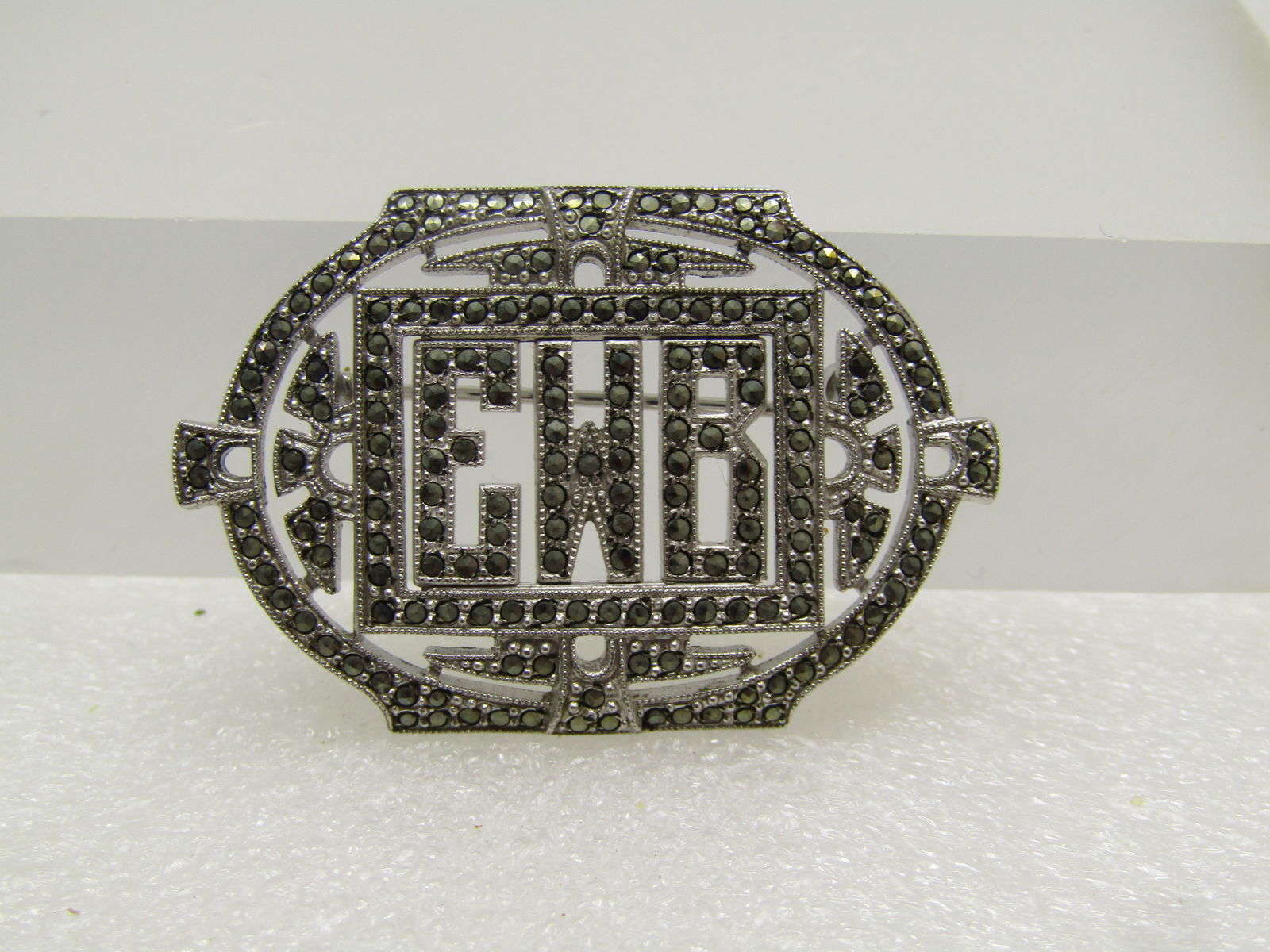 Vintage Sterling EWB Initial Marcasite Brooch, 1930's-1940's: Title:Vintage Sterling EWB Initial Marcasite Brooch, 1930's-1940'sDescription:Vintage Sterling EWB Initial Marcasite Brooch, 1930's-1940's. The brooch is oval shaped with a flat top and bottom and a