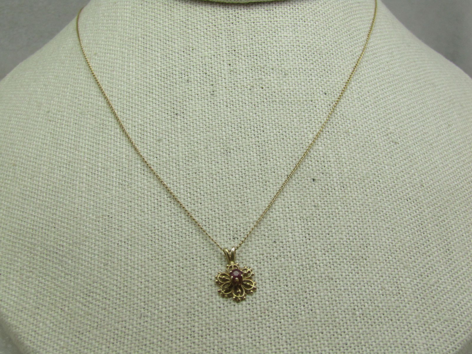 Vintage 14kt Ruby Blossom Necklace, 18", Signed: Title:Vintage 14kt Ruby Blossom Necklace, 18", SignedDescription:Vintage 14kt Ruby Blossom Necklace, 18", Signed what looks like a bell in a circle with an L in the bell. The pendant is apps 5/8"