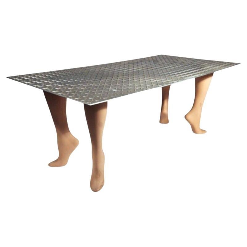 Playful Pop Art "Footsie" Coffee Table: Title: Playful Pop Art "Footsie" Coffee Table Description: This 1980s Pop Art "Footsie" coffee table features four elegantly arched mannequin legs supporting a textured Industrial steel top. Additiona