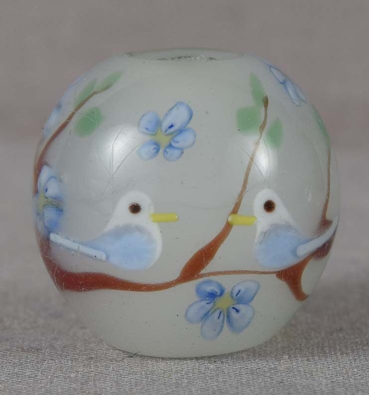 Japanese glass OJIME tombodama BIRDS ON BRANCH: Japanese glass ojime in a form of tombodama bead with white core and two birds on a long branch with leaves and flowers. Tombodama can be translated as “dragonfly ball” and the name is