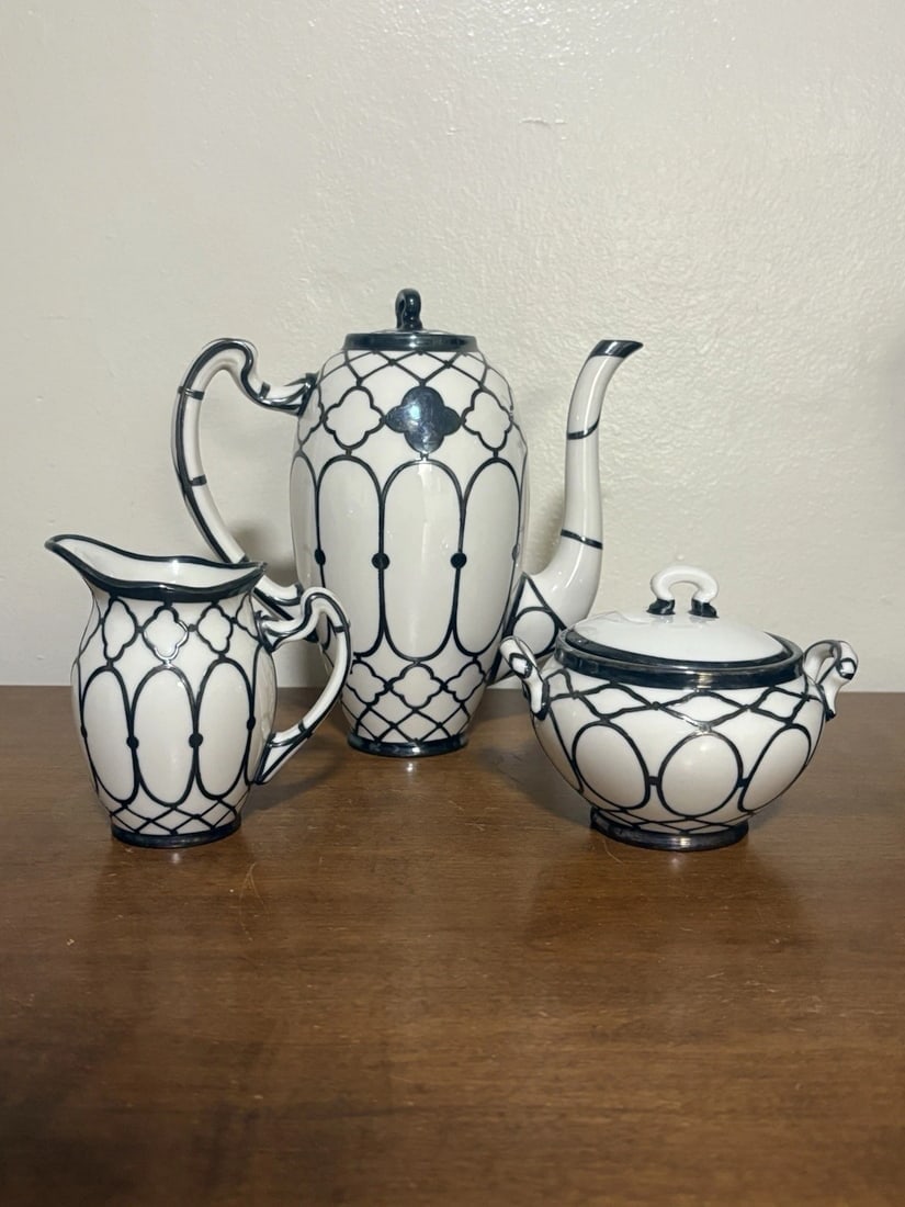 Lenox Porcelain Silver Overlay Tea Set: The teapot measures 7 5/8” high, the creamer is 4” high and the sugar is 3 3/4” x 4 7/8” and all three are marked. The set has no chips, cracks or repairs Shipping:Domestic: