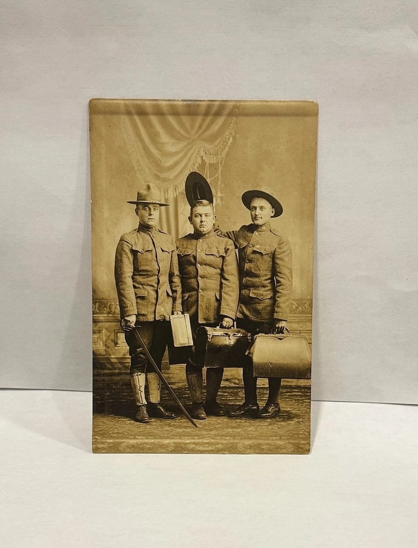 RPPC 3 Soldiers Gag Image Hats, Suitcases & Sword Circa 1900 - 1909 Patriotic: Real photo postcard gag image of 3 soldiers with one holding a hat in the air. They have suitcases and one has a sword. I would assume it was meant to infer that these men would be traveling perhaps
