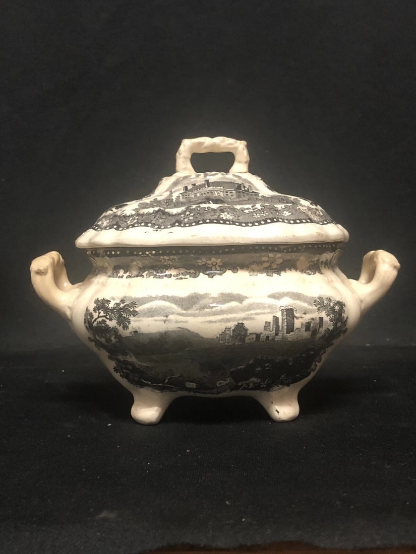 Fort Ticonderoga Historical Staffordshire Sauce Tureen: It measures 7 1/2” x 4 3/4” x 5 3/4” and is marked. The finial has been reglued. Otherwise it has no on chips, cracks or repairs. It is a hard pattern to find in staffordshire China