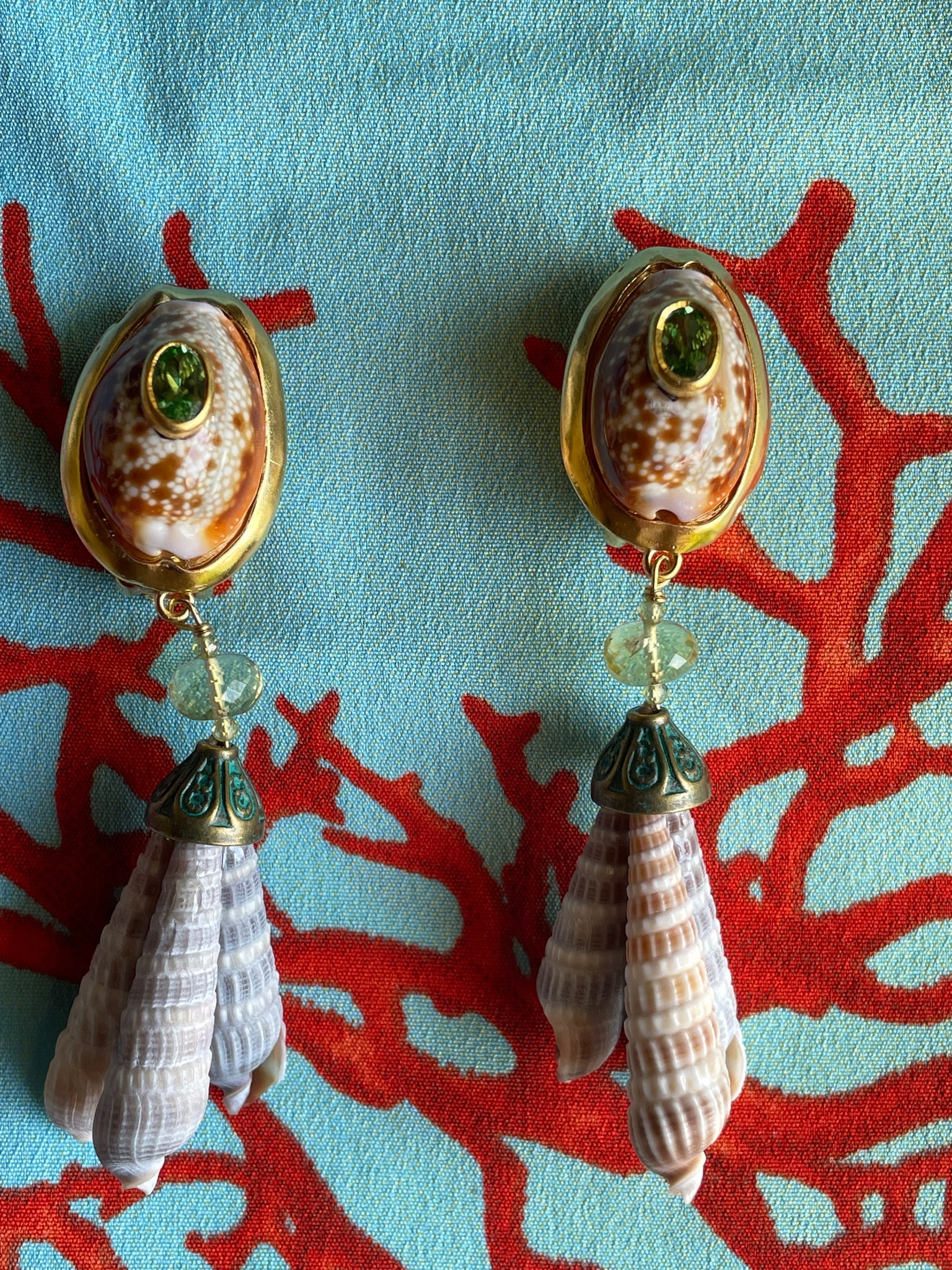 Rare Cowrie and Terebra Shell Drop Earrings: Title:Rare Cowrie and Terebra Shell Drop EarringsDescription:Light-hearted earrings that take a woman form day to evening. Rare Cowries and Terebra shells harvested in 1985. Vermeil and brass,