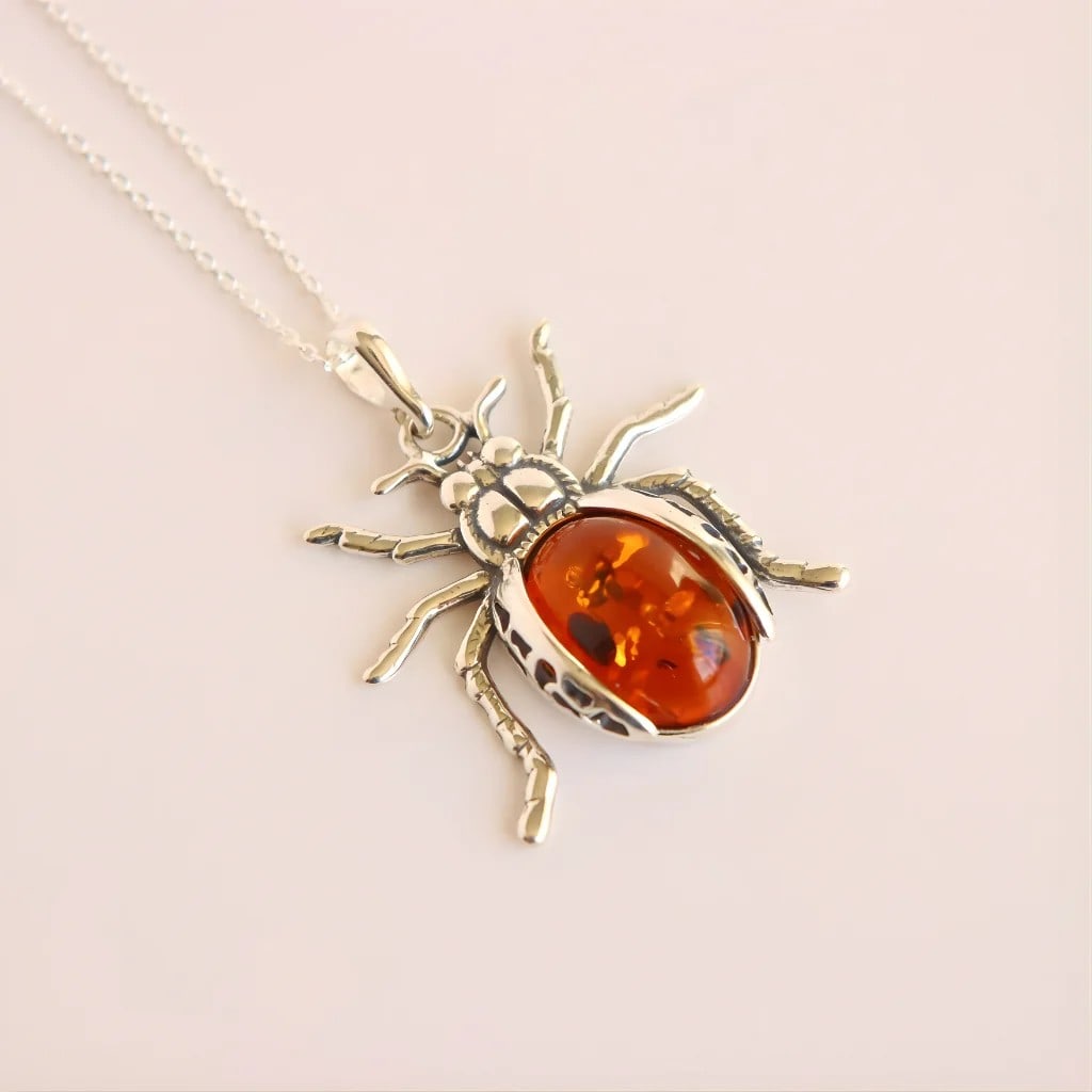 Baltic Cognac Amber Scarab Pendant in Sterling Silver: Title:Baltic Cognac Amber Scarab Pendant in Sterling SilverDescription:This amber pendant features a sculptural scarab design crafted in solid 925 sterling silver and set with Baltic cognac amber.