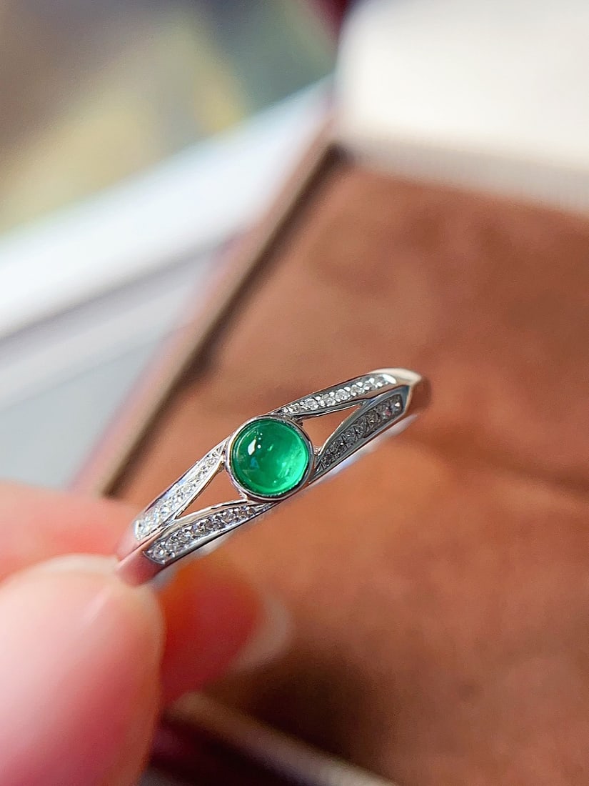 18K gold emerald ring: Title: 18K gold emerald ring Description: This ring showcases the bright luster of natural emerald set in exquisite 18K gold. The main stone is a striking 0.2 carat emerald, emitting a charming and