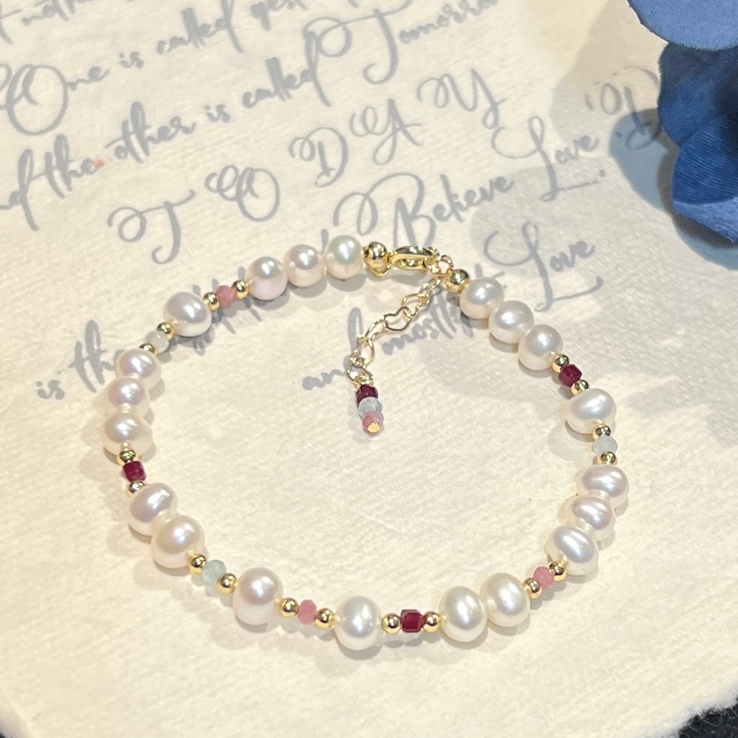 Pearl bracelet: Title: Pearl bracelet Description: This bracelet is a colorful feast, bringing together a symphony of sapphires, aquamarines, and rubies. The 5-6mm nearly round freshwater pearls add a touch of