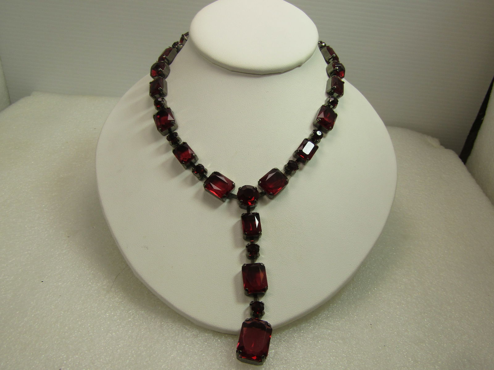 Purple Rhinestone Drop Necklace, Black Metal, 16". 1980's-1990's: Purple Rhinestone Drop Necklace, Black Metal, 16". 1980's-1990's. This is mostly rectangular clear acrylic faceted rhinestones in a mix of sizes with round matching stones between the rectangular