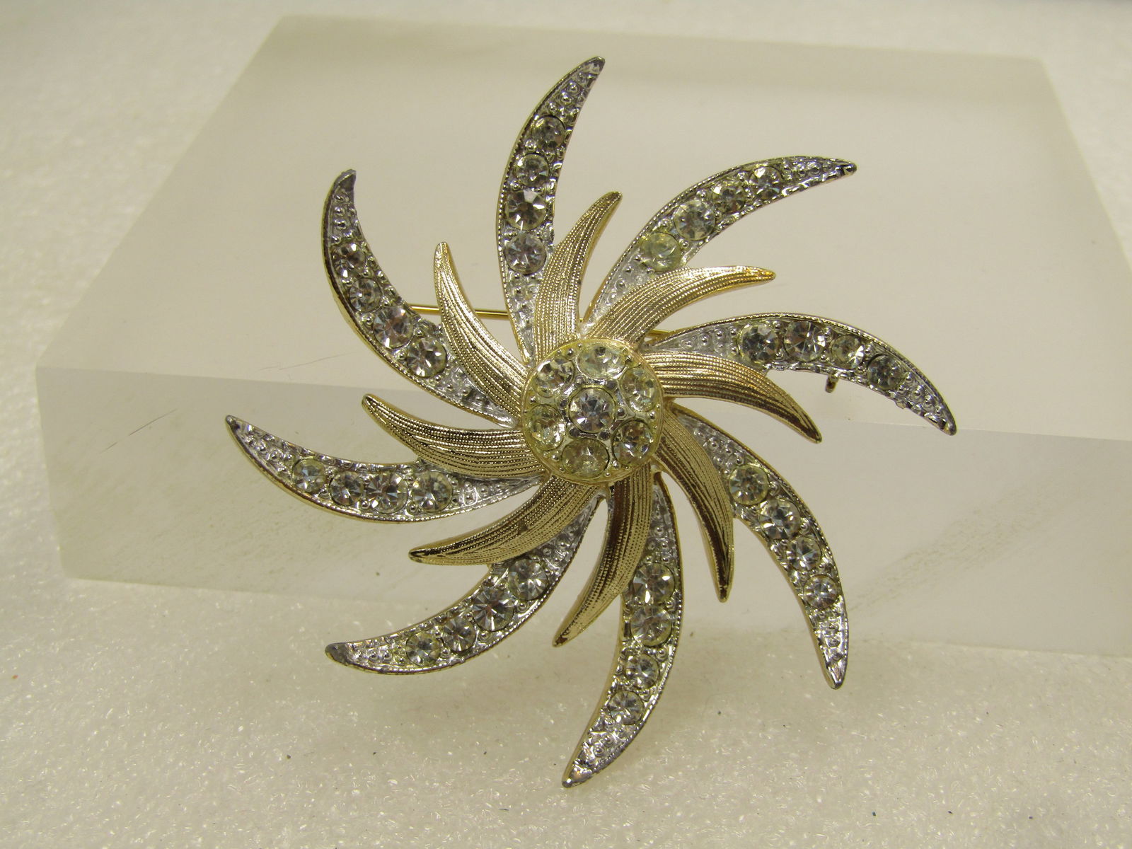 Vintage Pinwheell Rhinestone Brooch, Two-Tone, Sarah Coventry, 1960's-1970's: Vintage Pinwheel Spiral Rhinestone Brooch, Two-Tone, Sarah Coventry, 1960's-1970's. Mostly silver tone with pave-set rhinestones in the rays with textured gold tone shorter rays in the center and a