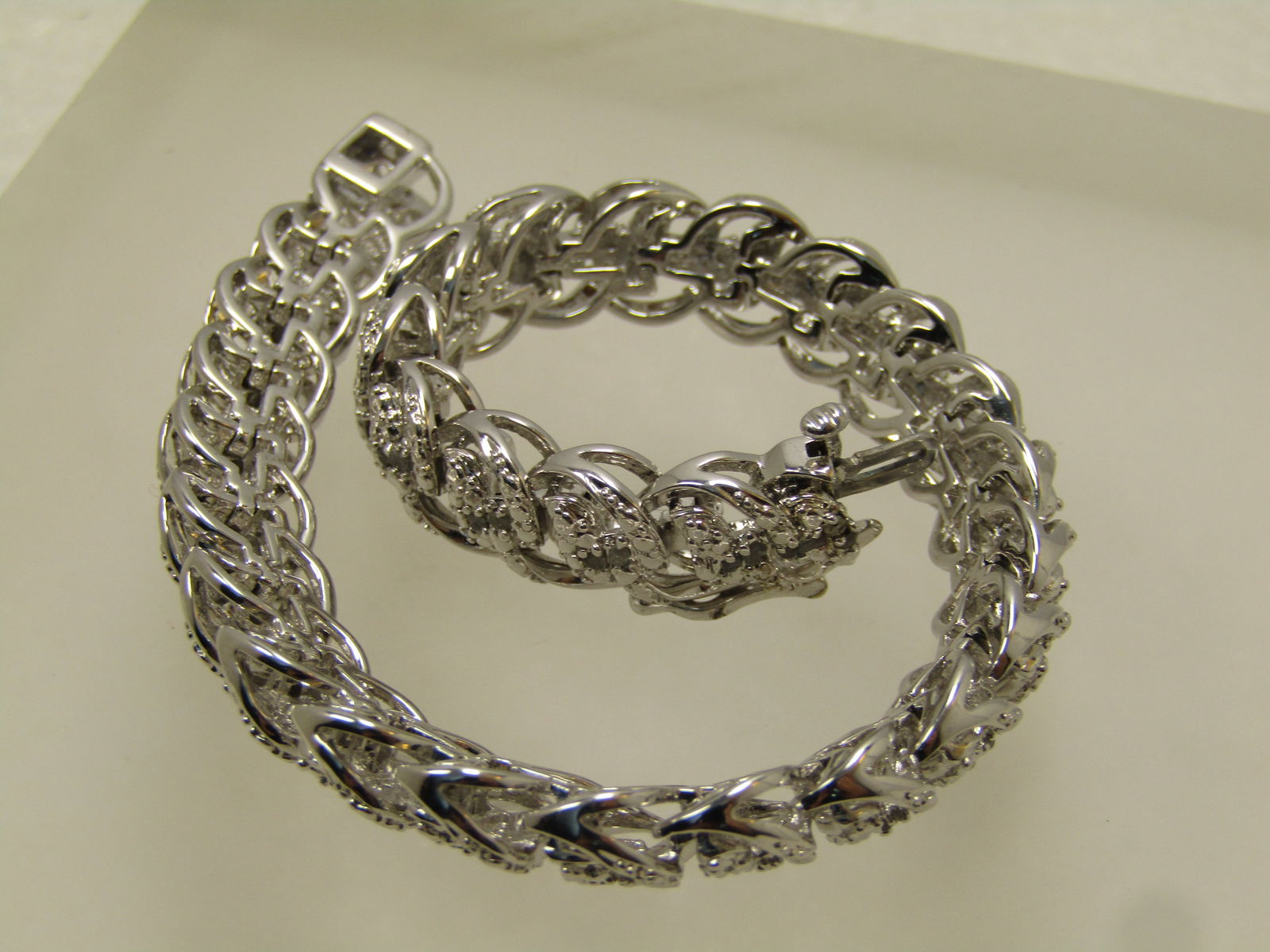 White Gold Plated Diamond Chip Bracelet, 7.5" 8.5mm Wide, Domed, Signed BR, 1980's-1990's: White Gold Plated Diamond Chip Bracelet, 7.5" 8.5mm Wide, Domed, Signed Br, 1980's-1990's. Safety clasp. Smooth curved links on the outer edes with a domed textured top that has a low grade diamond