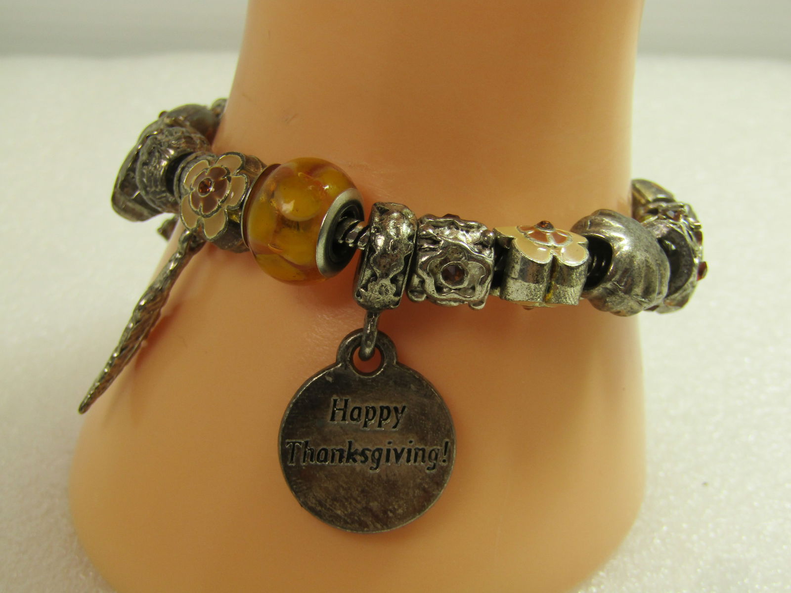 Vintage Silver Tone Thanksgiving Bracelet , Slide Charms, 7.5", 1990's: Vintage Silver Tone Thanksgiving Bracelet , Slide Charms, 7.5", 1990's. This has some glass and some enameled charms as well as all silver tone. there is a pilgrim hat; brown glass and yellow glass ;