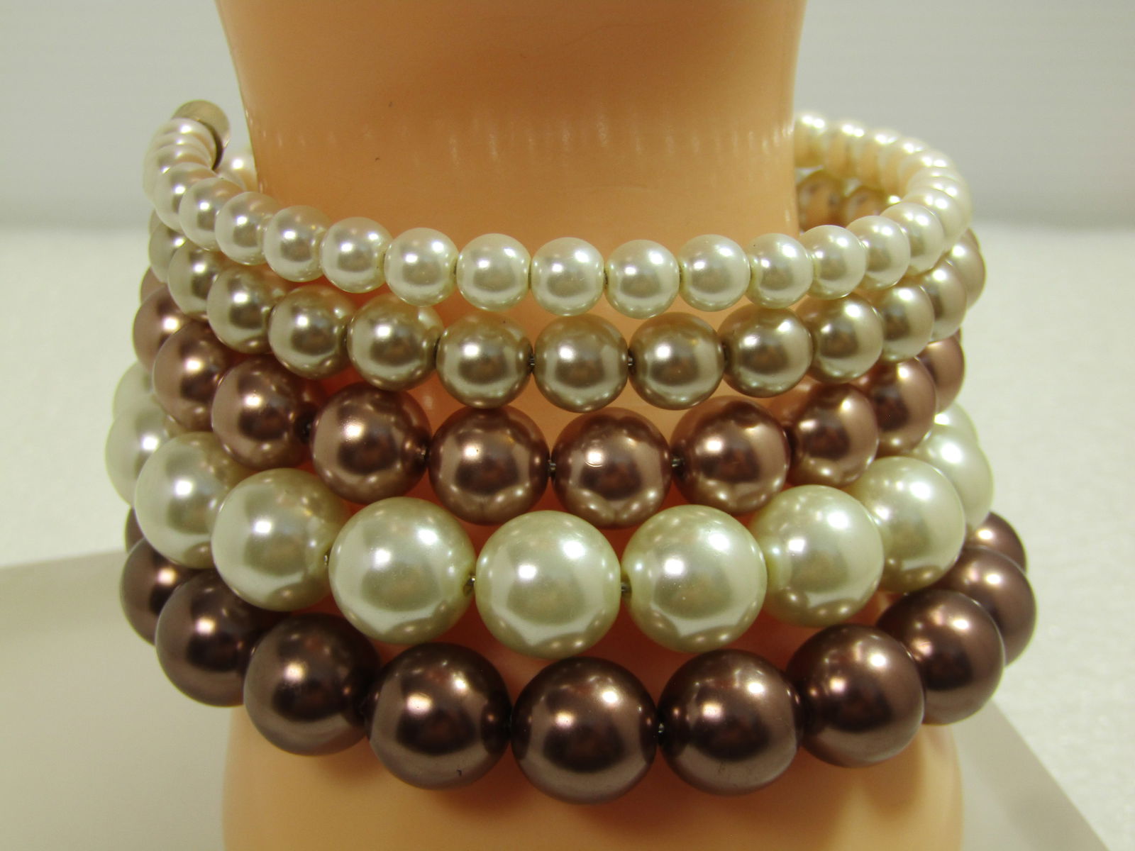 Graduated Five Coiled Faux Pearl Bracelet, White to Brown, 1990's: Graduated Five Coiled Faux Pearl Bracelet, White to Brown, 1990's. Coils from appx. 6mm to 11.5mm in white then blucsh and light tan to white and a darker tan. They have that Tahitian style
