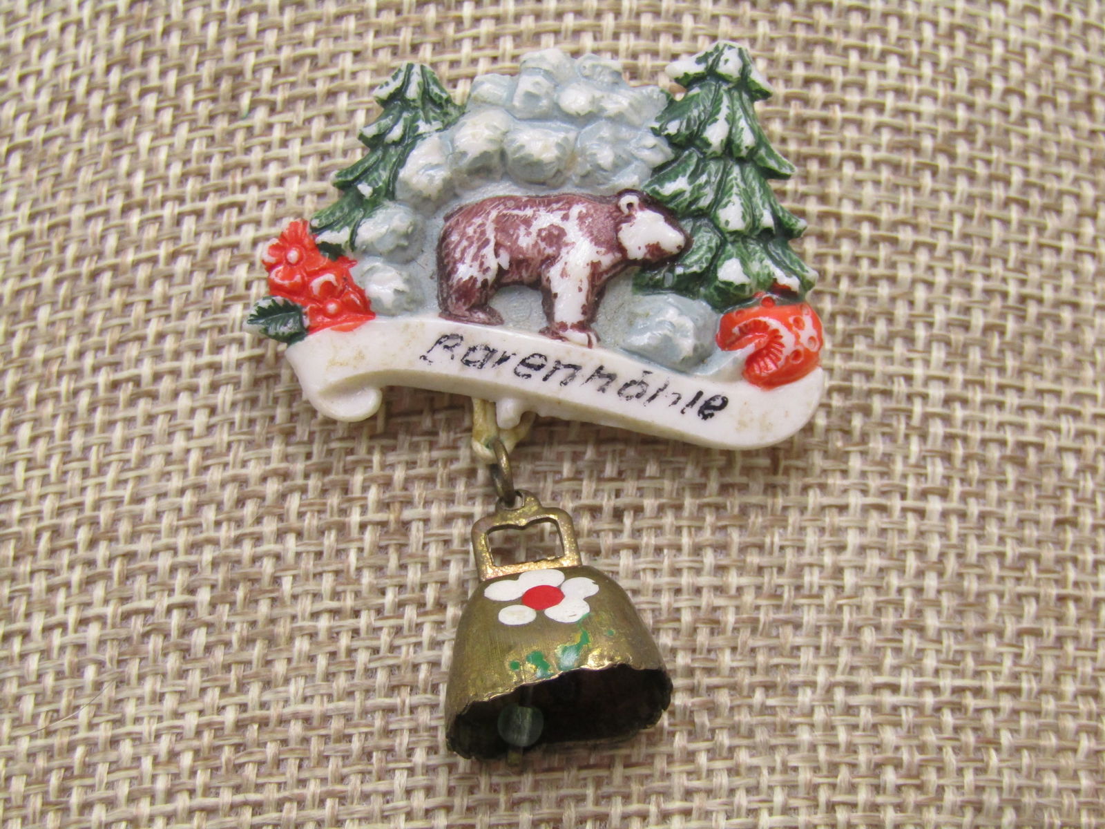 Vintage German Baenmohle Brooch, Alpine, Dangle Cow Bell, 1940's: Vintage German Baenmohle Brooch, Alpine, Dangle Cowbell, 1940's. A vintage German Bavenmohle-style brooch featuring a dangling cowbell, often associated with 1940s-1960s Alpine souvenirs, typically sh