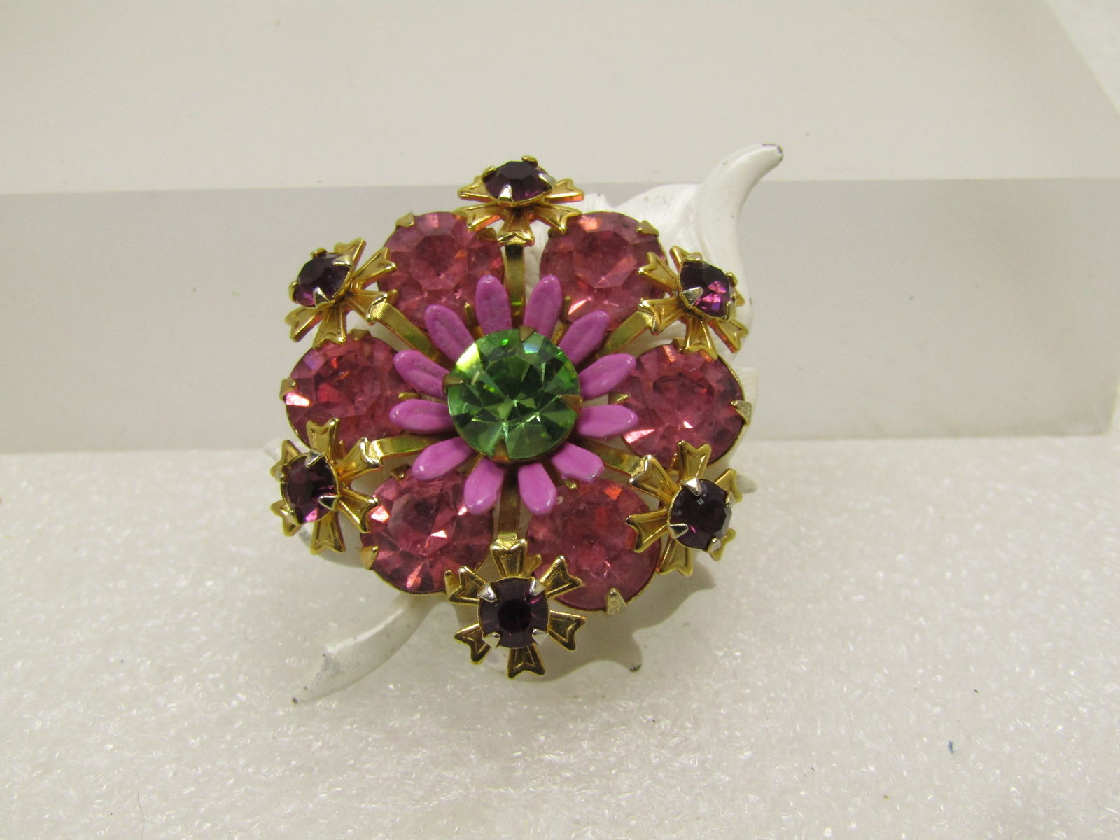 Vintage Enameled & Rhinestone Leaf Brooch, 1940's-1950's: Vintage Enameled & Rhinestone Leaf Brooch, 1940's-1950's. This is a white enameled leaf with textured detail on the surface as well as leaf edging. In the center is a riased pink rhinestone blossom wi