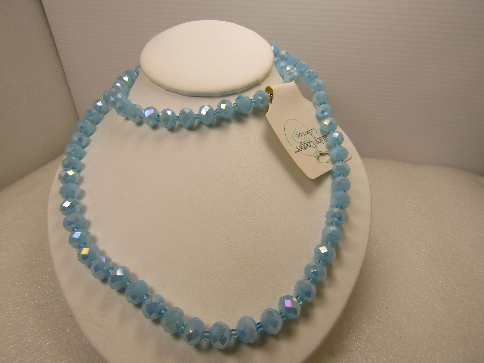 Blue Faceted Glass Beaded Necklace, Ashley Cooper, 32", 2000's With Tags: Blue Faceted Glass Beaded Necklace, Ashley Cooper, 32", 2000's With Tags. Light blue faceted beads that are appx. 9.5mm round with a blue glass seed bead between each of the larger beads. The larger b
