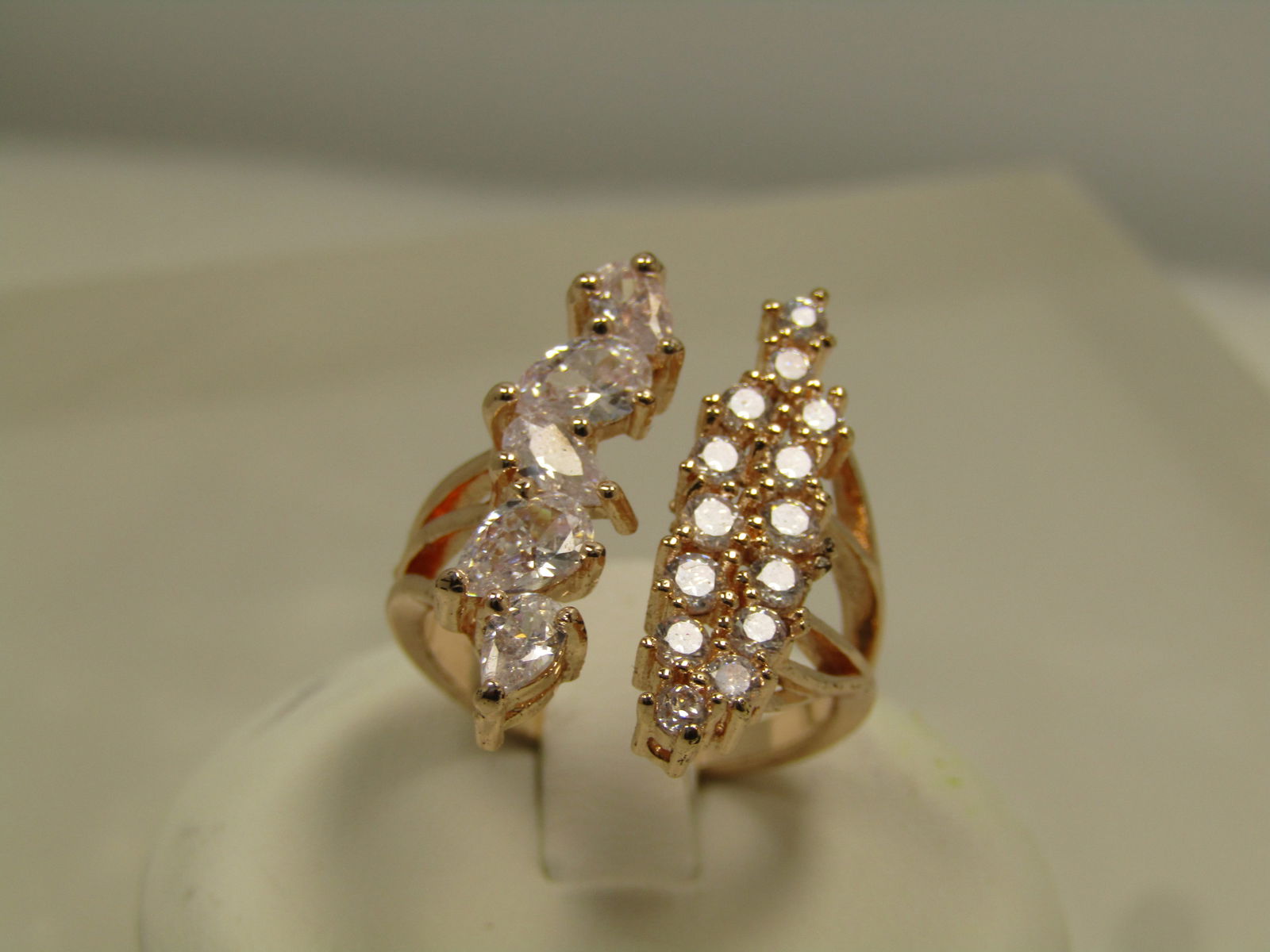 Rose Gold Clear Rhinestone Ring, Adjustable Sz 7.5 -10: Rose Gold Clear Rhinestone Ring, Adjustable Sz 7.5 -10. This has a branch design on the uper sides with three split bands an on one side there are pear-shaped clear rhinestones and on the other side