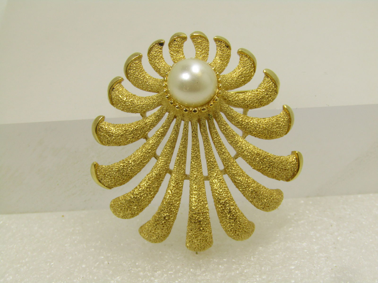 Vintage Crown Trifari Faux Pearl Brooch, Textured, Mid-Century: Vintage Crown Trifari Faux Pearl Brooch, Textured, Mid-Century. This has an offset faux white pearl, appx. 8mm set toward the top with ray-like tentacles reach outward from the pearl. They rays are cu