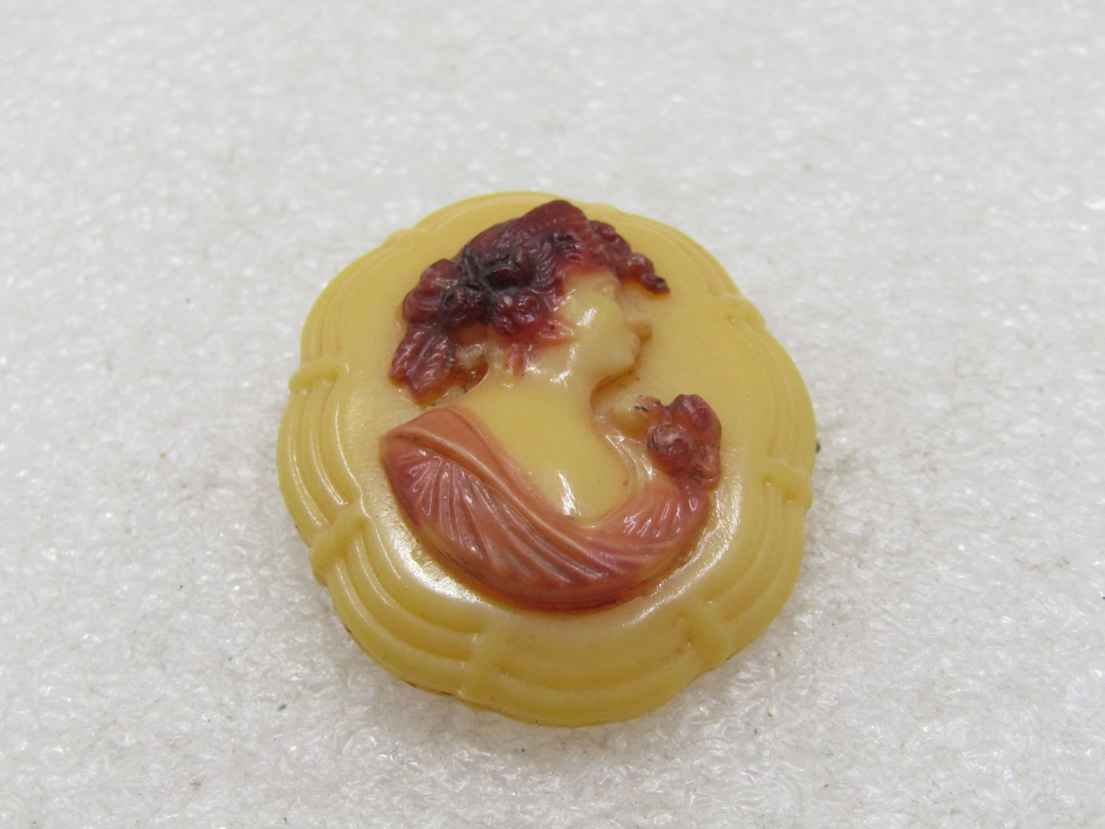 Vintage Plastic Cameo Brooch, Victorian Themed: Vintage Plastic Cameo Brooch, Victorian Themed, Appx. 1.5" long and 1" wide, slightly under. The cameo has dark brown hair and a rose tone gown and flower. Made of a pressed/molded plastidc it has a