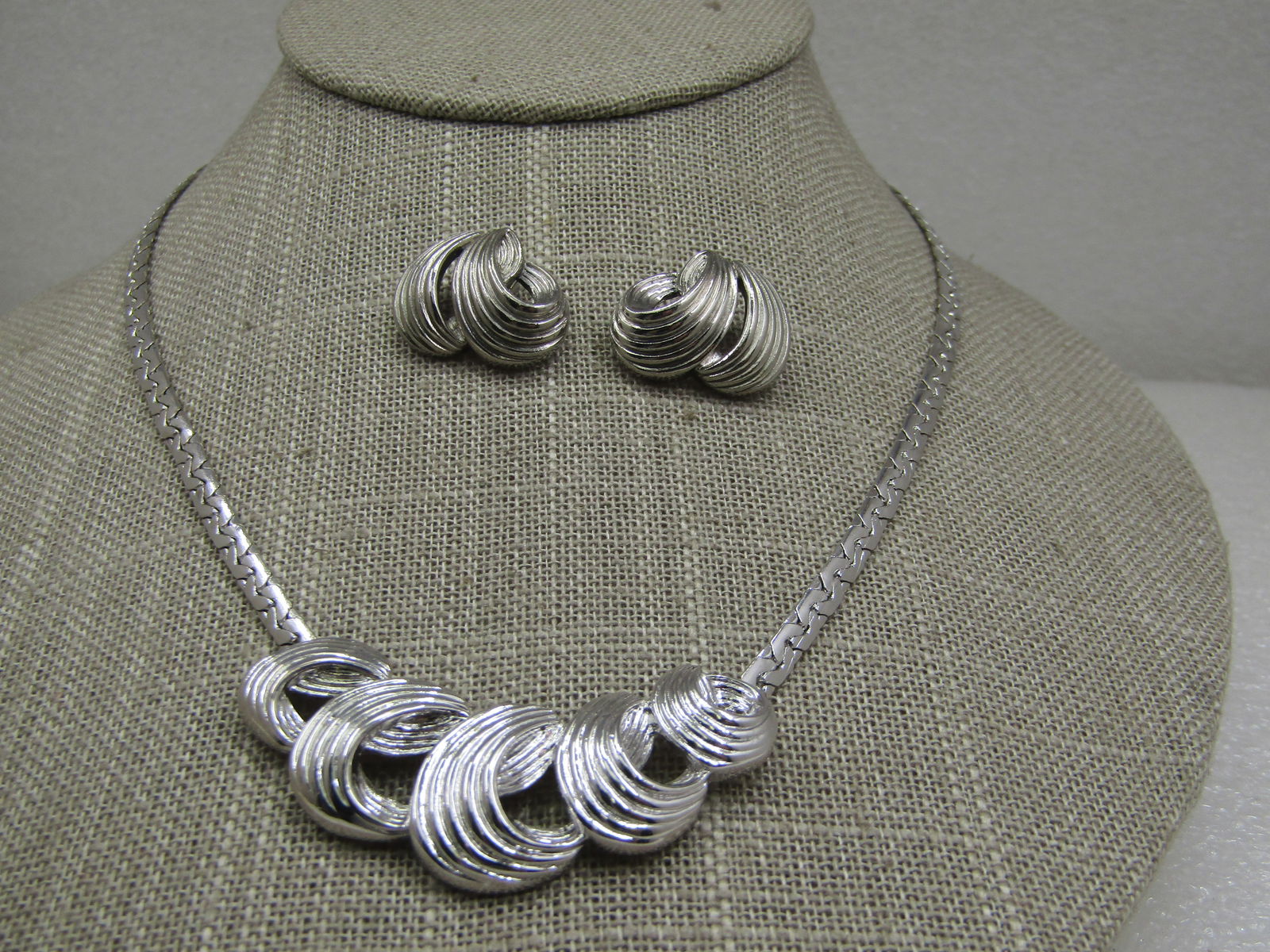 Vintage Silver Tone Ridged Necklace & Earrings Set, 1960's: Vintage Silver Tone Ridged Necklace & Earrings Set, 1960's, 16.5" long with an appx 3.5mm wide domed herringbone link and a curved fron that has graduated ridged wave-like accents. The pierced