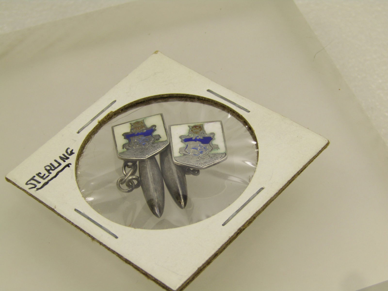 Vintage Sterling Enameled Lion/Ship/Shield Cufflinks , 1930's-1940's: Vintage Sterling Enameled Lion/Ship/Shield Cufflinks , 1930's-1940's. Sterling white background and blue enameled shield-shape cuf link with chain and long silver pointed back to the cufflink . This h