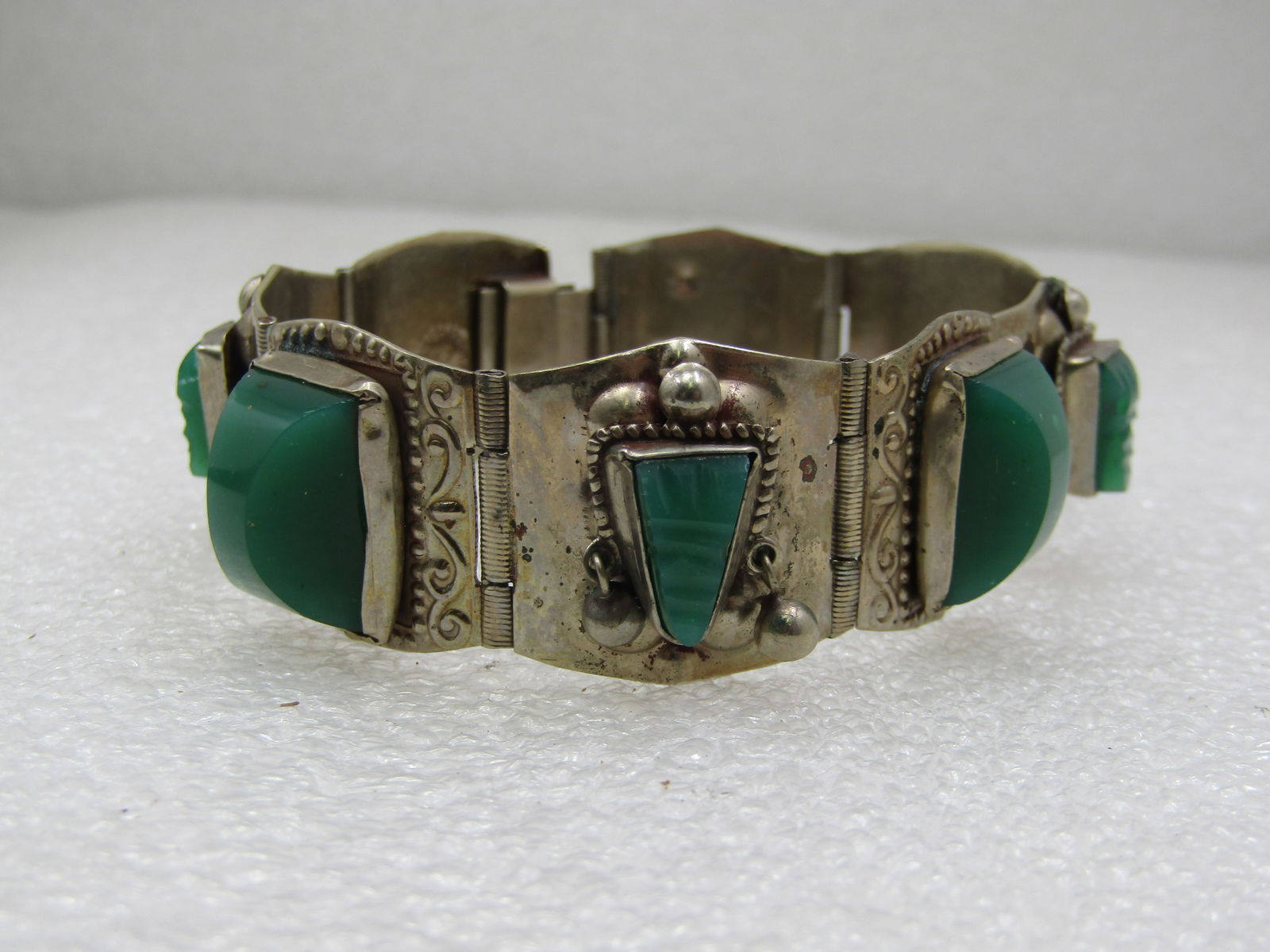 Vintage Alpaca Mexican Carved Green Bracelet, 7.25" Mask Tiles: Vintage Alpaca Mexican Carved Green Bracelet, 7.25" Mask Tiles. The tiles are appx. 9/10's of an inch. It alternates between 20mm by 15mm rectangular domes tile links and triangular carved masks that