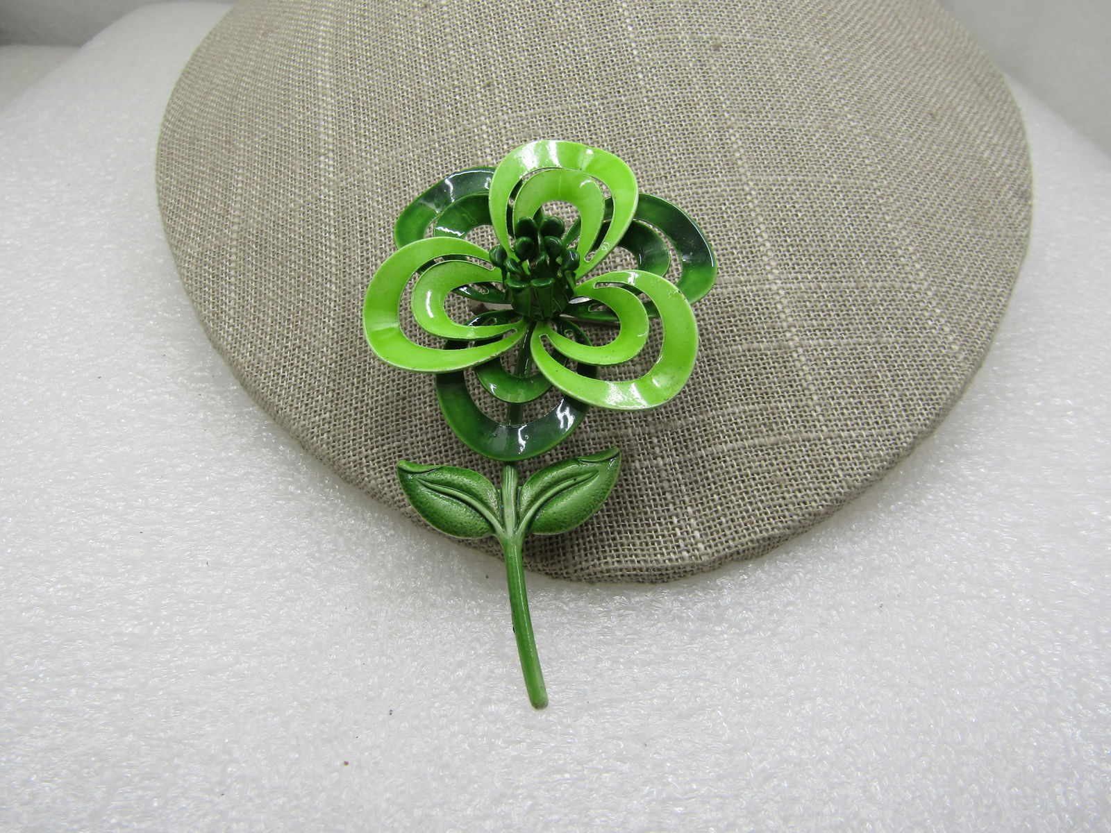 Vintage Green Enameled Floral Blossom and Stem Brooch, 1960's: Vintage Green Enameled Floral Blossom and Stem Brooch, 1960's, 3" tall and 2" wide. Two shades of green with open cut out tiered petals with stem and two leaves. White enameled undercarriage. Very goo