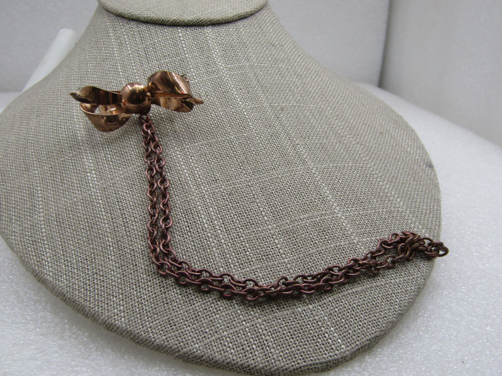 Vintage Rose Gold Bow with 6.5" Drop Chain: Vintage Rose Gold Bow with 6.5" Drop Chain. This may have been a sweater guard and is missing a bow but also a brooch with a chain drop that glasses were hooked through often worn by store clerks,