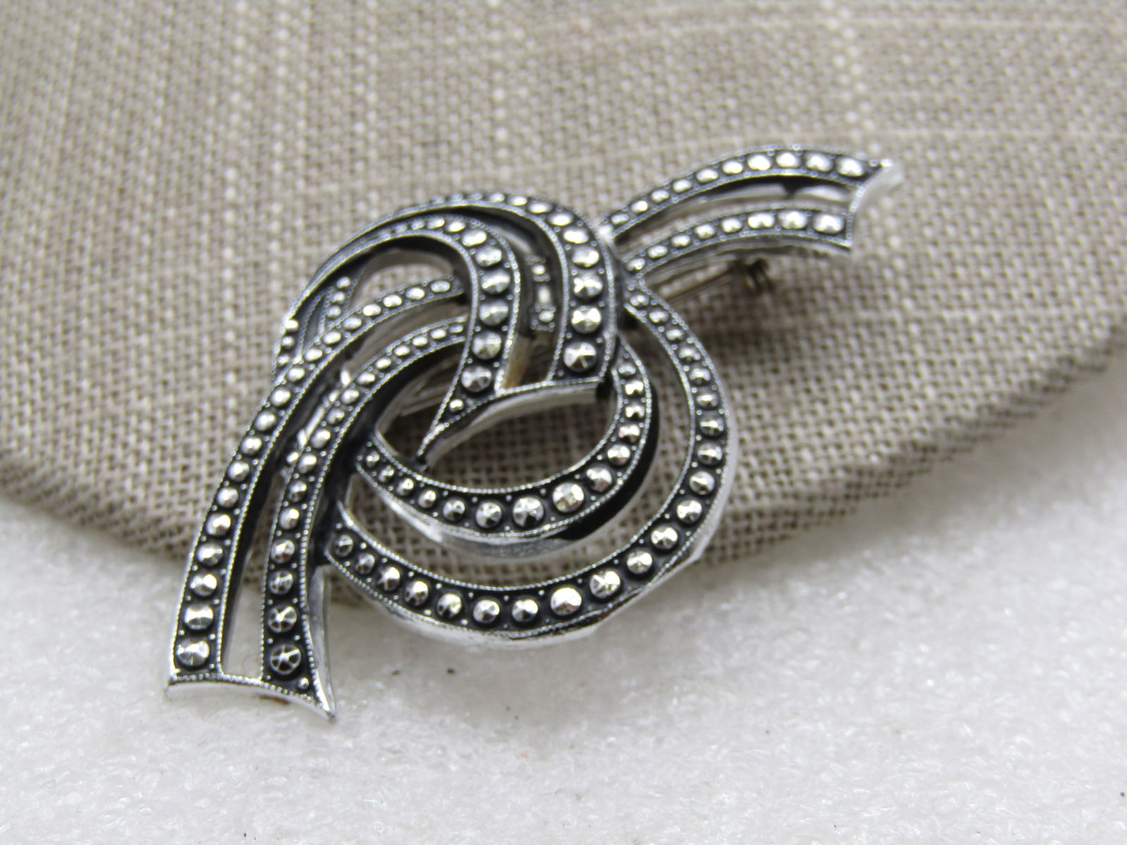 Vintage Simulated Marcasite Looped Bow Brooch, W. Germany, 1960's: Vintage Simulated Marcasite Looped Brooch, W. Germany, 1960's, silver tone and signed Made W Germany. It is 2.25" long nad 1.25" tall. Lightweight silver tone metal. A doubled looped bow. Very good co