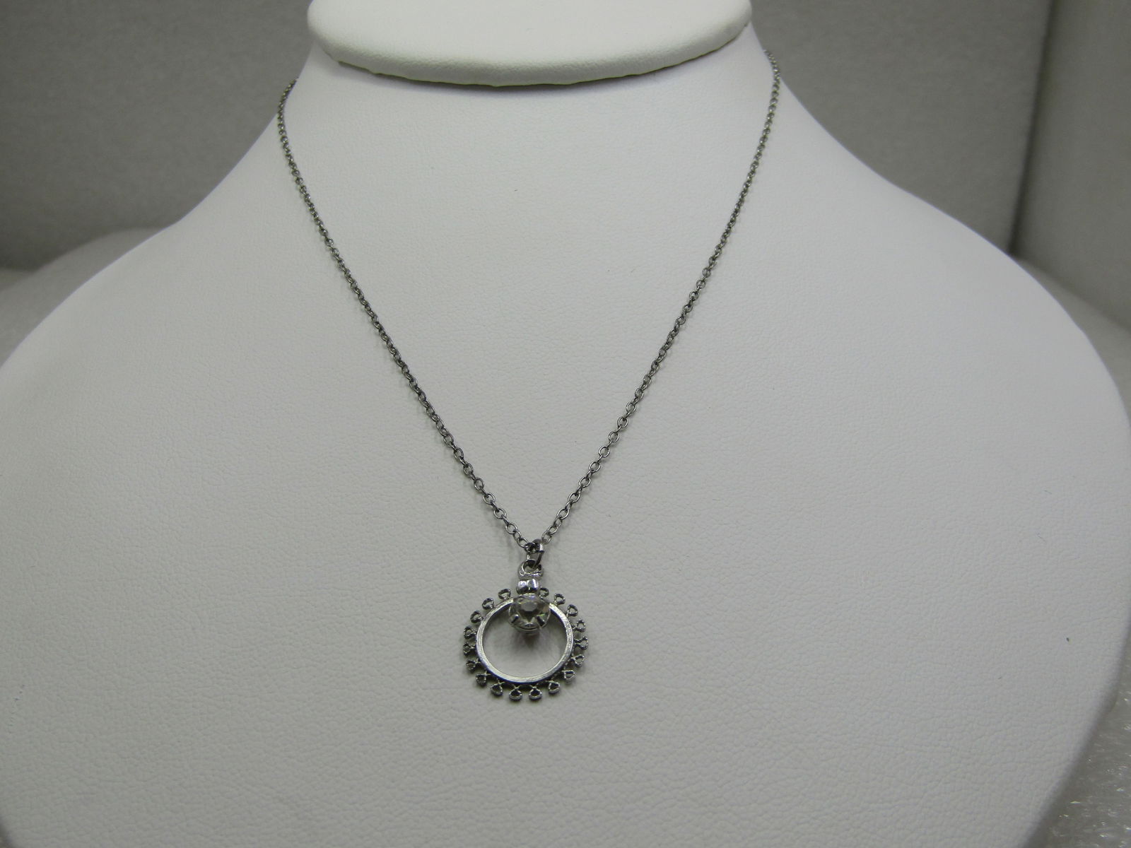 Vintage Sterling CZ Filigree Circle Necklace, 15": Vintage Sterling CZ Filigree Circle Necklace, 15", 5/8" long pendant incuding bail that is appx. 1.2" wide. It has a center clear CZ, round cut, that is appx. 4mm. The chain is an appx. 1mm chain