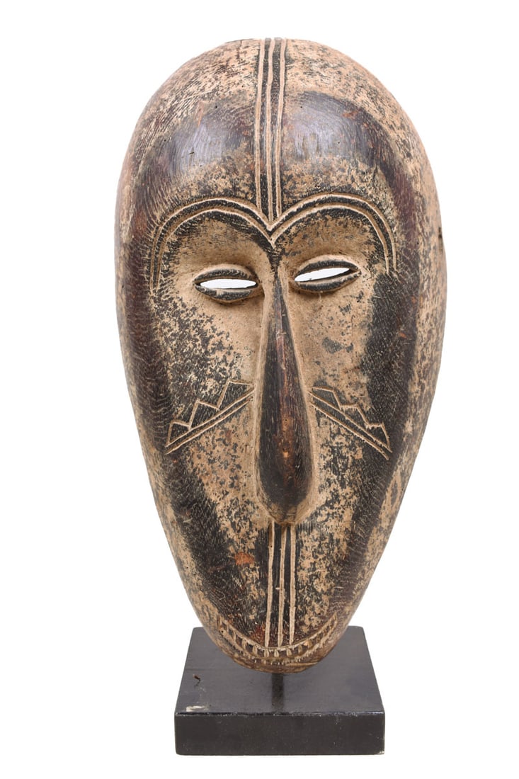 Ngil mask – Wood – Fang – Gabon: Beautiful mask from the NGIL society from the FANG tribe of Gabon. This mask was carved in a sublime and rustic style. With a long nose and a mouth all under the mask, half-rounded eyes. The mask is