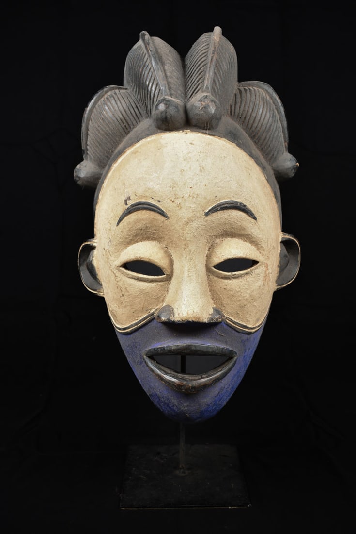 Initiation mask – Wood – Punu – Gabon: Decorative wooden initiation mask from the PUNU tribe, Gabon. PUNU masks are thought to represent ancestors` faces. They are worn during funerals and by a Moukouji initiate who stands on stilts. This