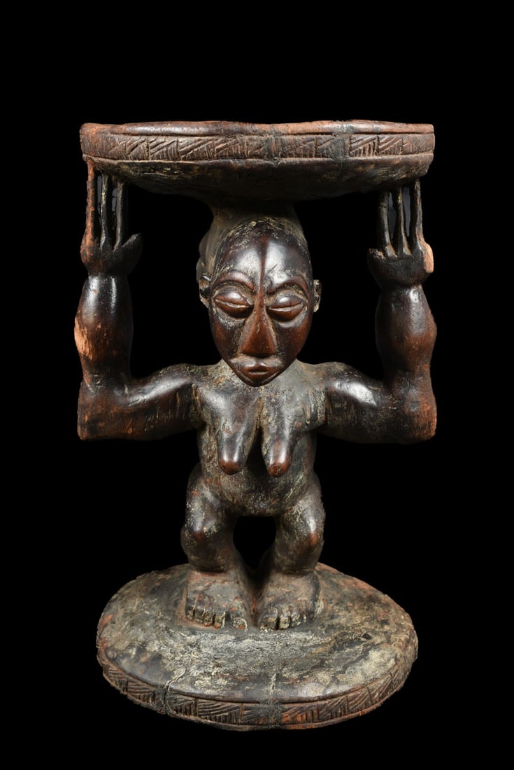 Stool – Wood – Luba – DR Congo: Powerfull Luba stool from DR Congo. Wondeful aged patina and great stylistic and detailed hairdo. In many cultures throughout the southeastern region of the Democratic Republic of Congo the seats of l
