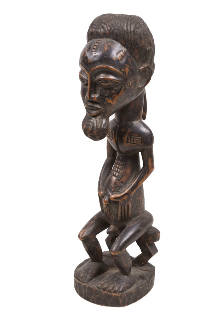 Ancestor figure – Baule – Wood – Ivory Coast: Beautiful Baule seated figure from Ivory Coast. Baule statues usually vary from 10 to 60 cm in height. They are are known for their figures with hands resting on their abdomen in a gesture of peace,