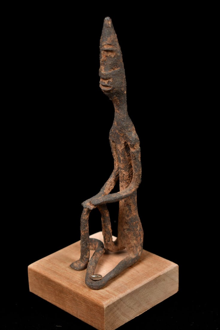 Ancestor Figure – Bronze – Dogon – Mali: A kneeling Dogon bronze figure from Mali. The Dogon have a highly sophisticated artisan tradition of art and is primarily mirror-images, aproned figures, and standing sculpture. Dogon art revolves aro