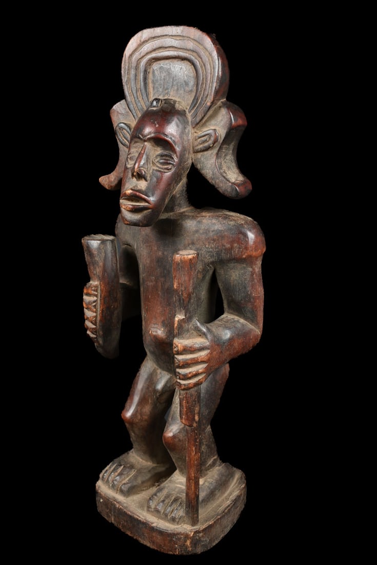 Tshibinda Figure – Wood – Chokwe – Congo: Beautiful wooden Chibinda figure from the Chokwe people of DR Congo This figure represents the hero Chibinda Ilunga, royal ancestor of the Chokwe people. By association, Chibinda Ilunga became a cultu