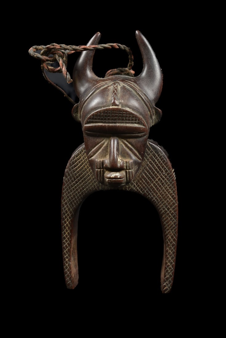 Pulley – Djimini – Wood – Ivory Coast: Djimini, Ivory Coast: a typical heddle pulley with ancestor head. A heddle pulley, in which a reel runs over an axle below. With a thread over this reel, the weaver can separate the warp threads of hi