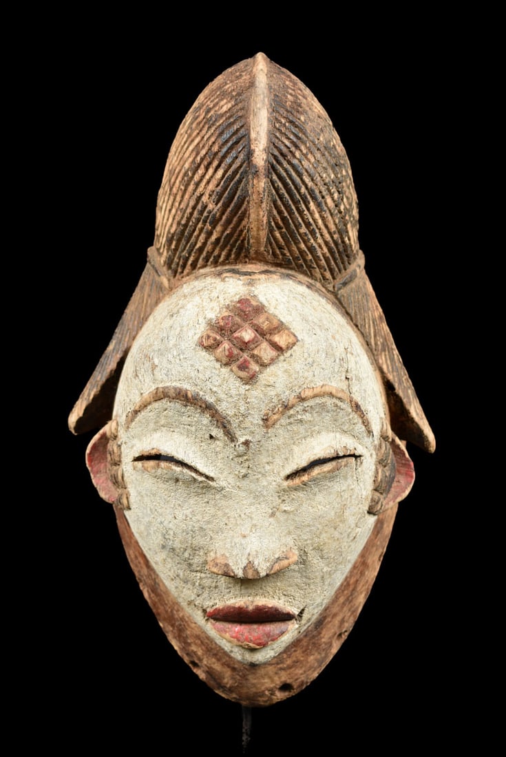 Initiation mask – Wood – Punu – Gabon: Wooden initiation mask from the PUNU tribe, Gabon. PUNU masks are thought to represent ancestors` faces. They are worn during funerals and by a Moukouji initiate who stands on stilts. This masks has a