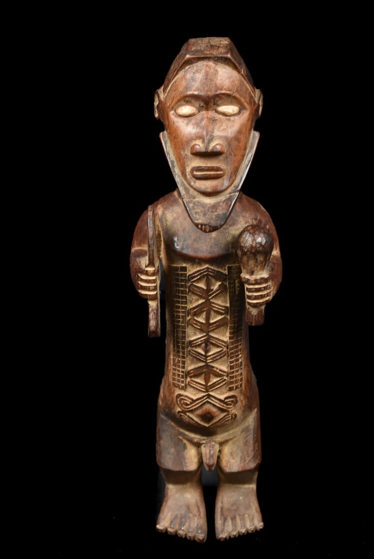 Power Figure – Wood – Bembe – DR Congo: Great refined ancestor figure with child on his back from the Babembe people of DR Congo. Good aged patina with beautifull scarifications on the body. The function of Bembe art is said to be primarily