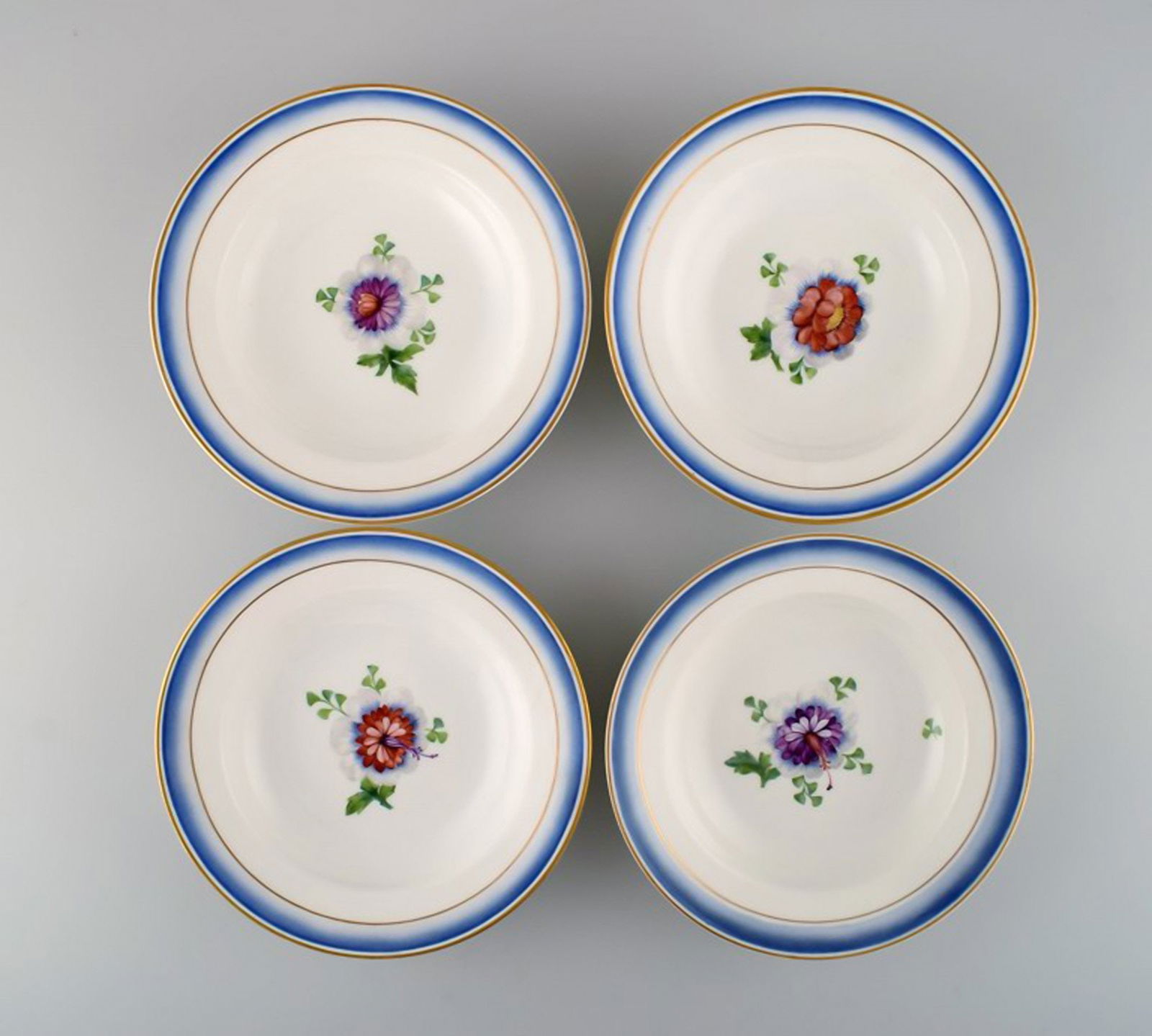 Four antique Royal Copenhagen deep plates in hand-painted porcelain with flowers and blue edge with: Title: Four antique Royal Copenhagen deep plates in hand-painted porcelain with flowers and blue edge with gold. Model number 592/9050. Late 19th century. Description: Four antique Royal Copenhagen de