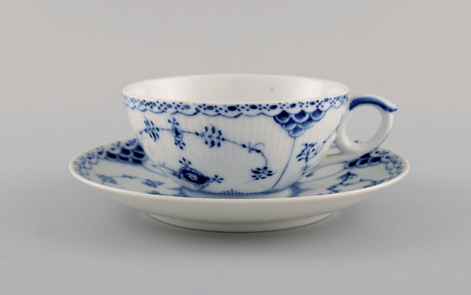 Royal Copenhagen Blue Fluted Half Lace teacup with saucer. Model number 1/525. Dated 1942.: Title: Royal Copenhagen Blue Fluted Half Lace teacup with saucer. Model number 1/525. Dated 1942. Description: Royal Copenhagen Blue Fluted Half Lace teacup with saucer. Model number 1/525. Dated