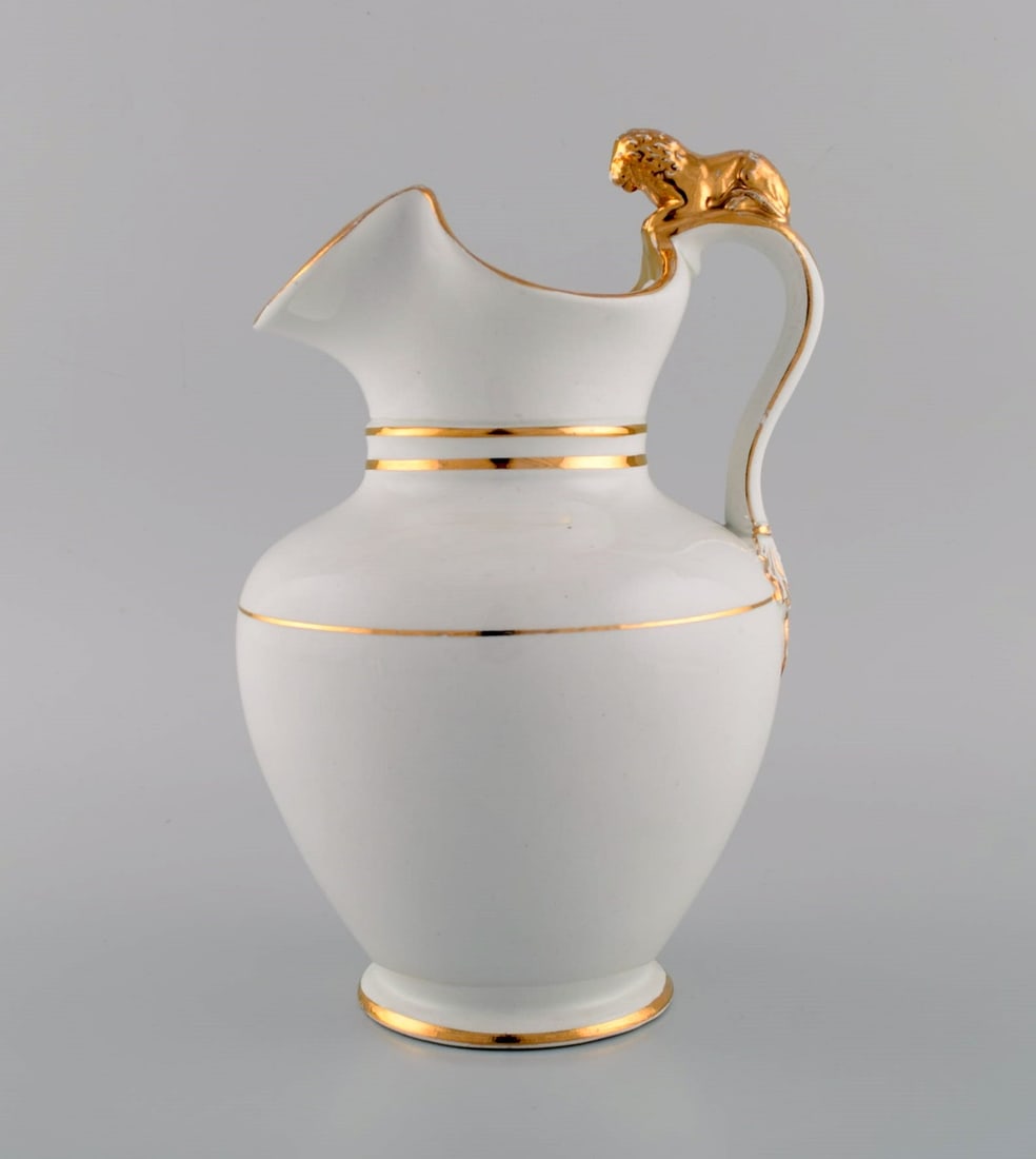 Antique Gustafsberg chocolate jug in porcelain modeled with a lion on the handle. Hand-painted gold: Title: Antique Gustafsberg chocolate jug in porcelain modeled with a lion on the handle. Hand-painted gold decoration. Late 19th century. Description: Antique Gustafsberg chocolate jug in porcelain mo