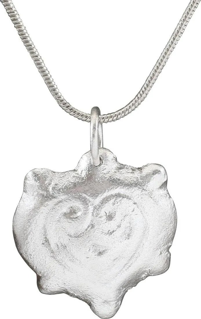 EXTRAORDINARY VIKING HEART PENDANT 850-1050 AD: Fine example in its fully evolved form. Over 7/8” in height. Fully evolved heart form with a very broad border and a heart within surrounded by another border, the sides scrolling at the top