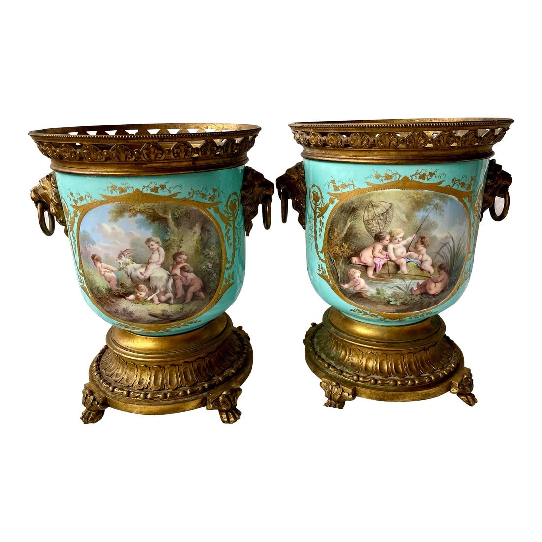 Early 20th Century Sevres Style Hand Painted Cherub Ceramic Gilt Metal Cache Pot a Pair: Here is a pair of hand painted cache pots with fantastic depictions of cherubs cavorting on one side of the pot and an artistic collage of decorative images on the other. The eggshell blue background